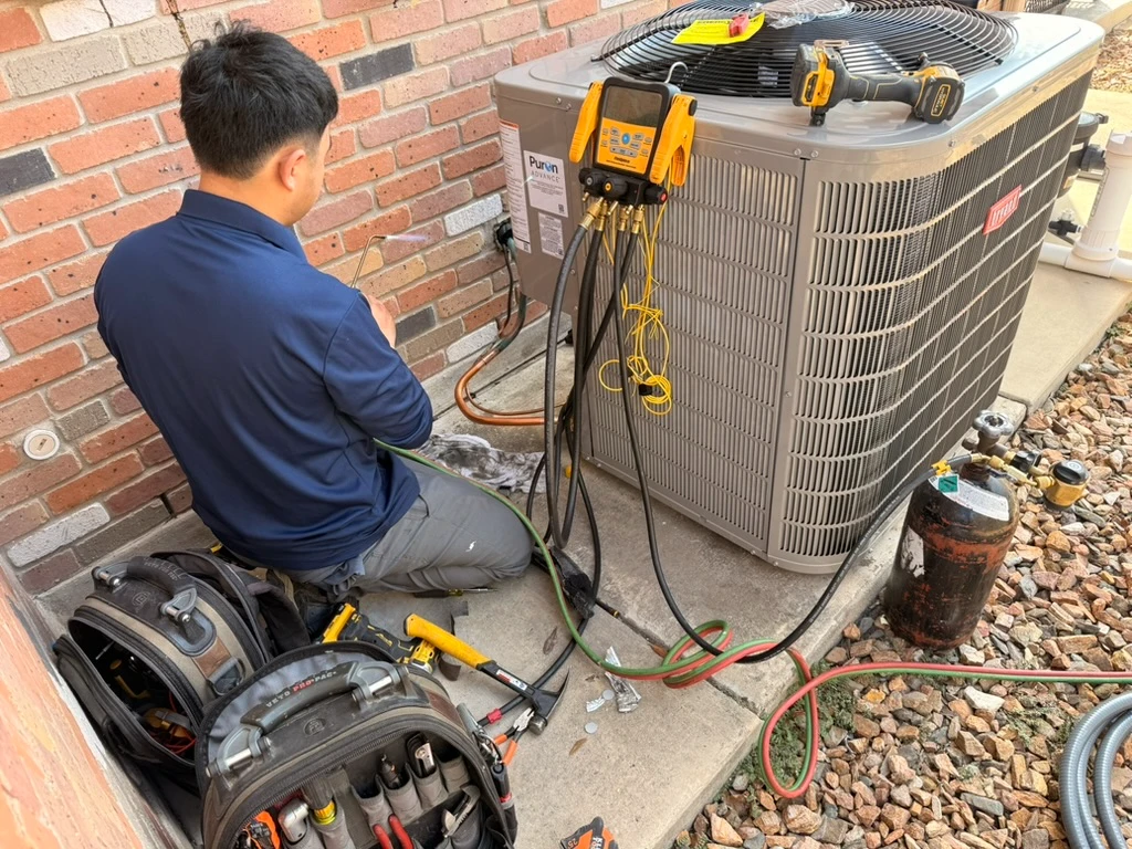 HVAC technician performing maintenance on an air conditioning unit in Pflugerville, TX