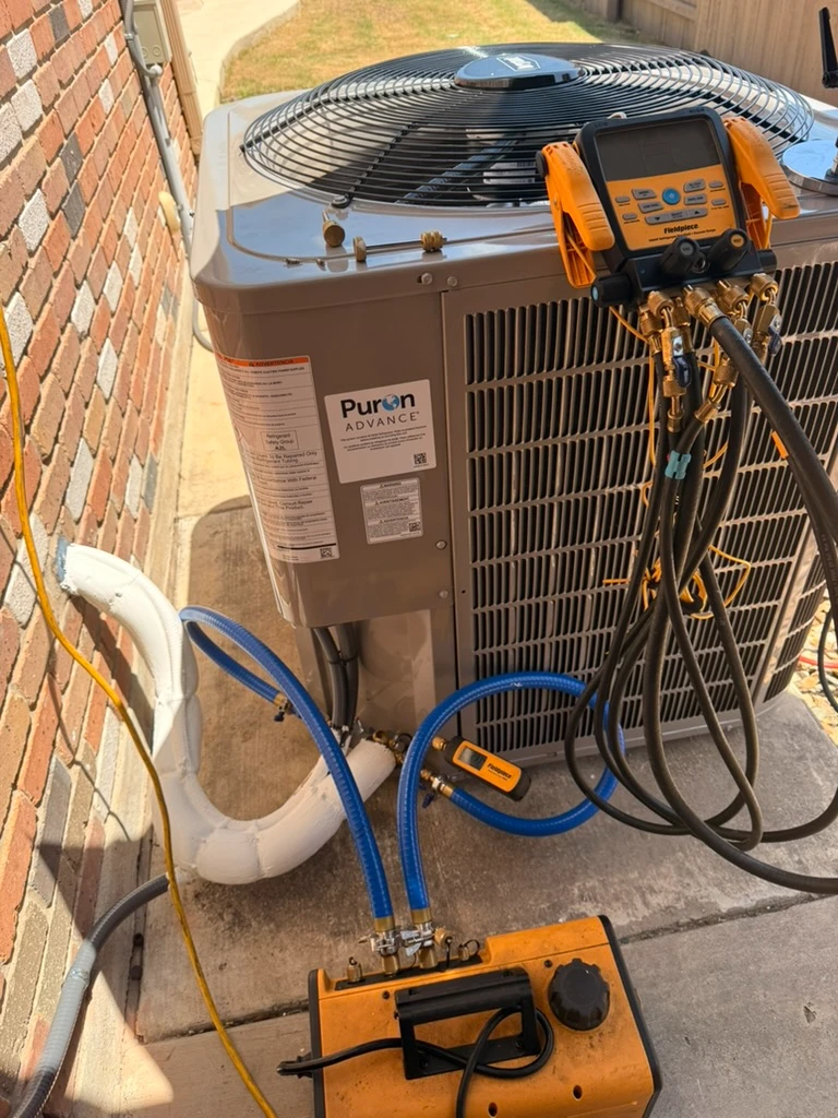 HVAC services Pflugerville TX featuring a Puron Advance unit with diagnostic tools and hoses connected.