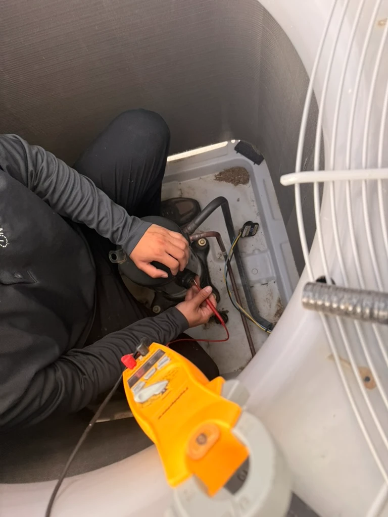 Technician performing HVAC services in Pflugerville, TX, using diagnostic tools for system maintenance.