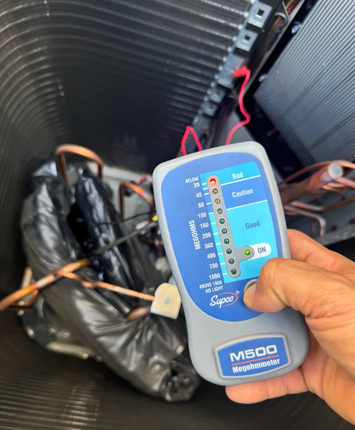 HVAC services Pflugerville TX technician using a megohmmeter to assess equipment performance.