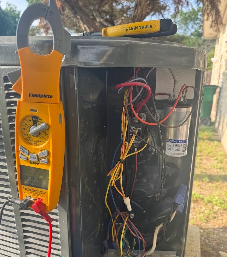 Clamp meter connected to air-conditioning equipment during electrical diagnostics
